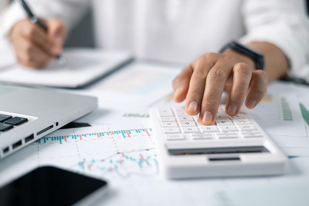 Businessman looking at pharmacy performance using a calculator